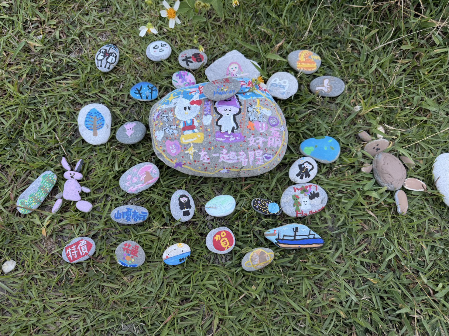 草地上擺滿親子石頭彩繪作品